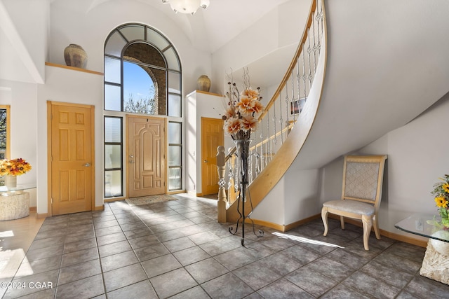 tiled entrance foyer featuring a towering ceiling