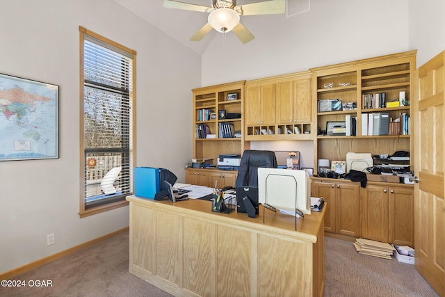 office featuring ceiling fan, built in desk, light colored carpet, and lofted ceiling