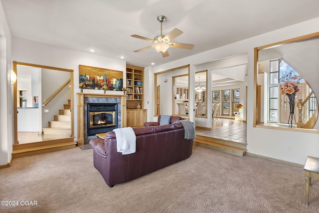 living room featuring built in shelves, ceiling fan, and carpet