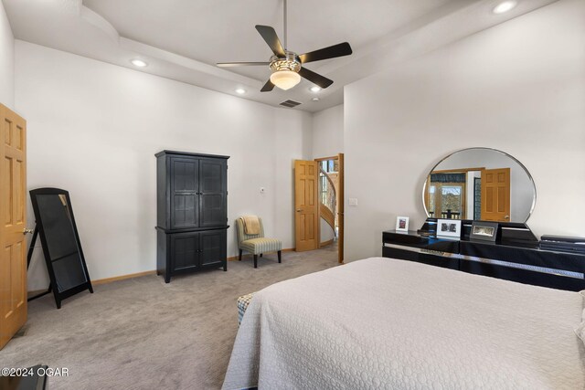 bedroom with carpet flooring, ceiling fan, and a high ceiling