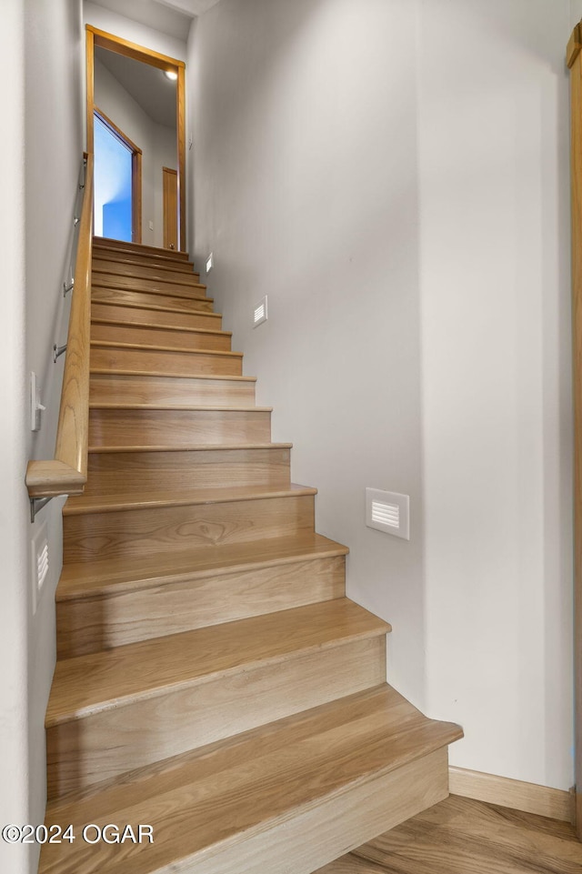 stairs featuring hardwood / wood-style flooring