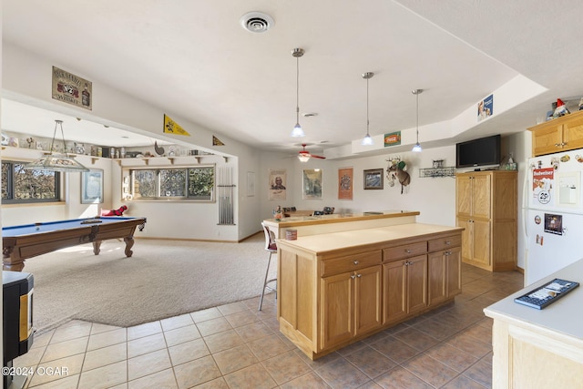 kitchen featuring pendant lighting, a kitchen island, pool table, white fridge, and light colored carpet