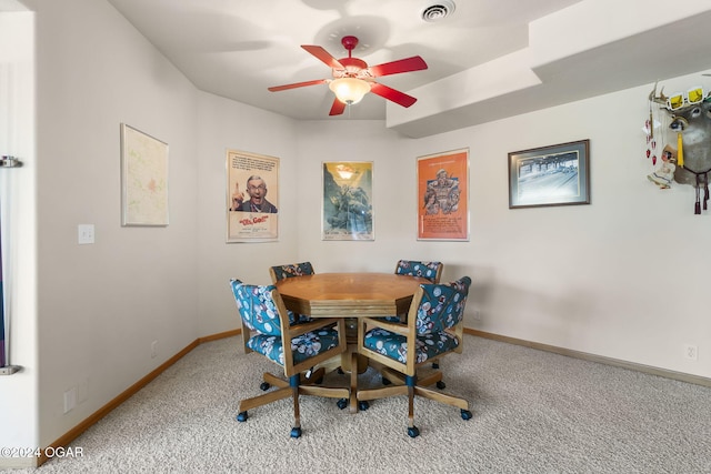 carpeted dining space with ceiling fan