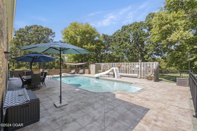 view of pool with a patio area and a water slide