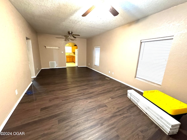 spare room featuring dark hardwood / wood-style floors, ceiling fan, and a textured ceiling