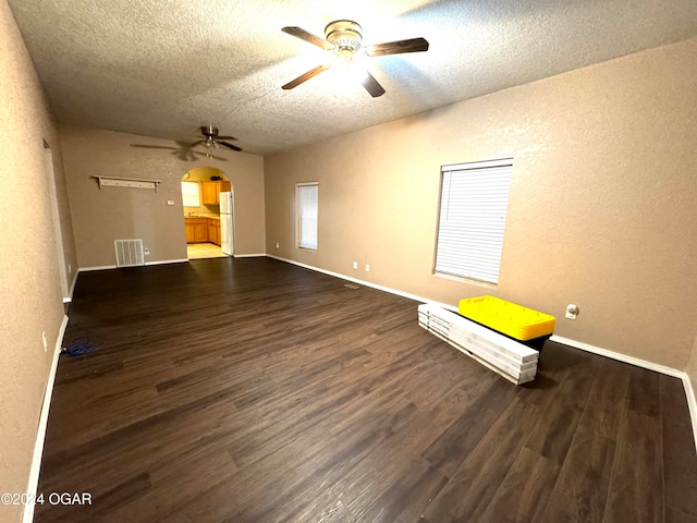 empty room featuring a textured ceiling, dark hardwood / wood-style flooring, and ceiling fan