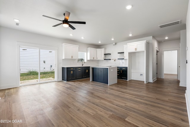 kitchen featuring tasteful backsplash, ceiling fan, hardwood / wood-style flooring, white cabinets, and a center island