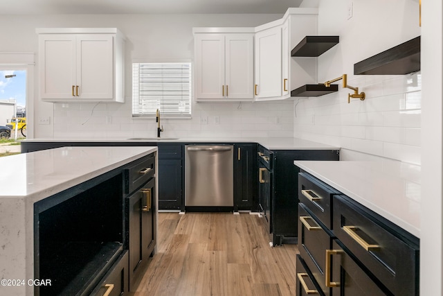 kitchen with dishwasher, white cabinets, sink, tasteful backsplash, and light hardwood / wood-style floors