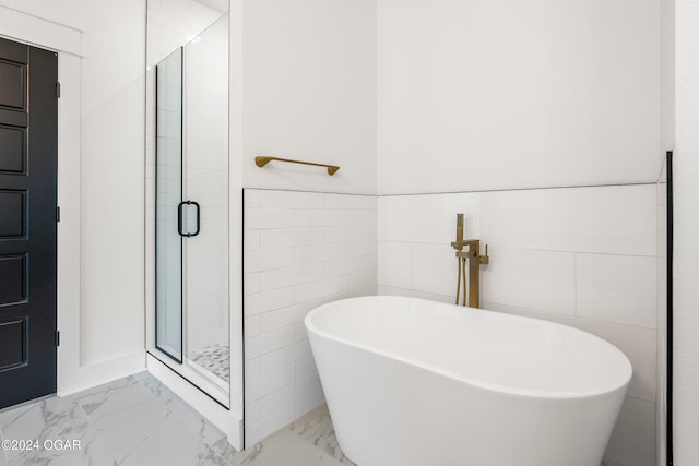 bathroom with separate shower and tub and tile walls