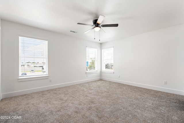 carpeted empty room with ceiling fan and a healthy amount of sunlight