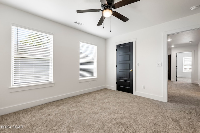 unfurnished bedroom featuring light colored carpet and ceiling fan