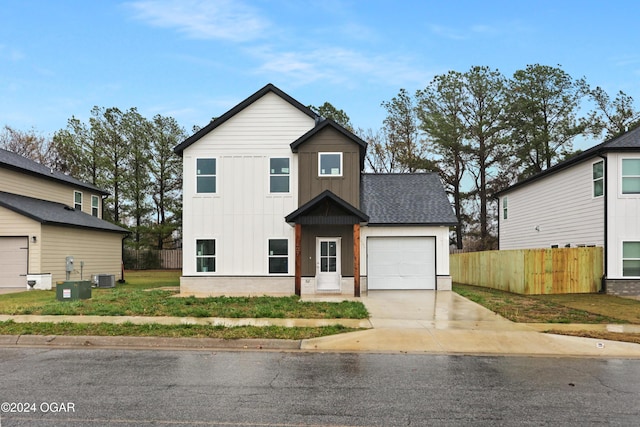 view of front of house featuring a front yard, a garage, and central air condition unit