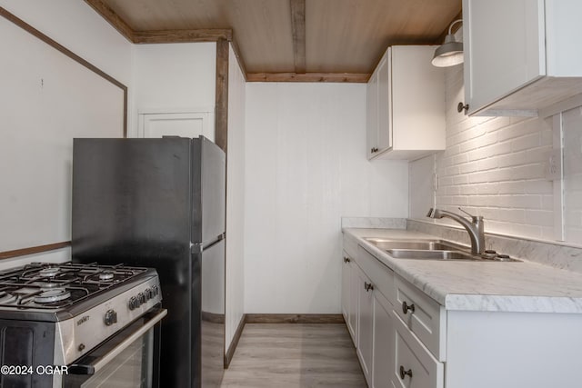 319-323 N Harlem Ave, Joplin, MO 64801 - kitchen with stainless steel gas range, a sink, light countertops, white cabinetry, and light wood-style floors