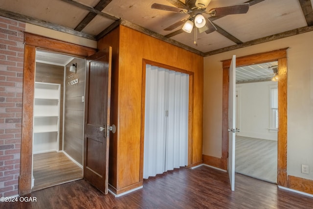 319-323 N Harlem Ave, Joplin, MO 64801 - unfurnished bedroom featuring dark wood-style floors, wooden walls, baseboards, and ceiling fan