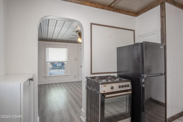 319-323 N Harlem Ave, Joplin, MO 64801 - kitchen with gas stove, freestanding refrigerator, arched walkways, wood finished floors, and a ceiling fan