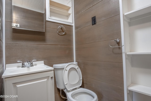 319-323 N Harlem Ave, Joplin, MO 64801 - bathroom featuring toilet, vanity, and wood walls