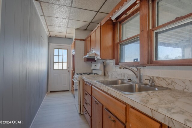 319-323 N Harlem Ave, Joplin, MO 64801 - kitchen featuring gas range gas stove, a sink, light countertops, and brown cabinetry