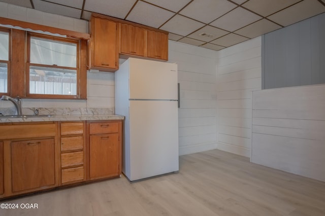 319-323 N Harlem Ave, Joplin, MO 64801 - kitchen with freestanding refrigerator, a sink, light wood-style flooring, light countertops, and a paneled ceiling