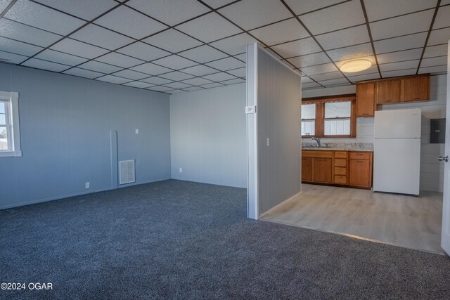 319-323 N Harlem Ave, Joplin, MO 64801 - kitchen featuring freestanding refrigerator, brown cabinetry, light colored carpet, light countertops, and a paneled ceiling
