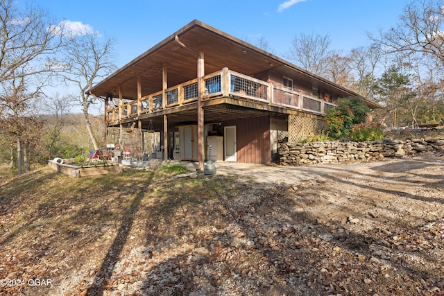 rear view of house featuring a wooden deck