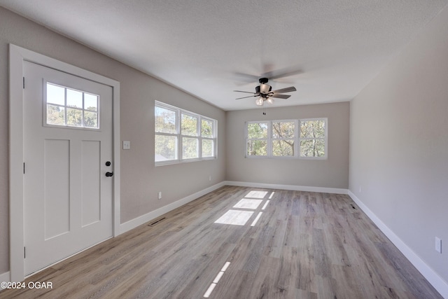 foyer featuring plenty of natural light, ceiling fan, a textured ceiling, and light hardwood / wood-style flooring