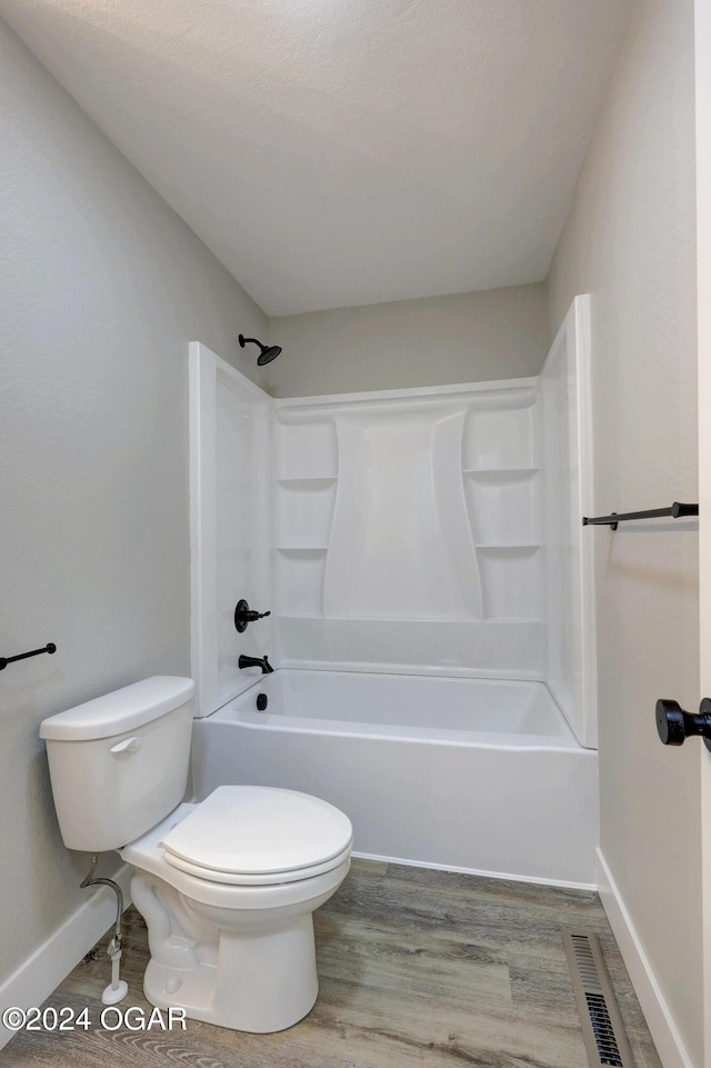 bathroom with  shower combination, toilet, and wood-type flooring