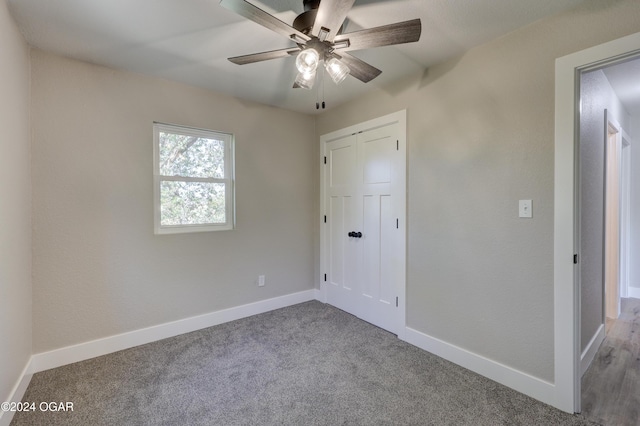 unfurnished bedroom featuring carpet floors, a closet, and ceiling fan