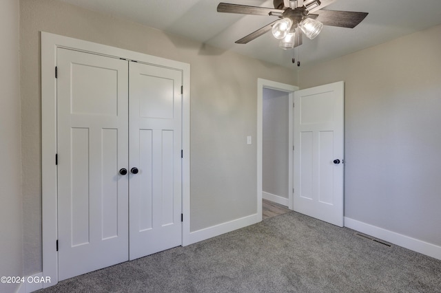 unfurnished bedroom featuring ceiling fan, a closet, and light carpet