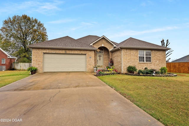 ranch-style house with cooling unit, a front lawn, and a garage