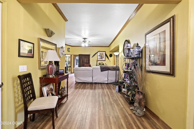 living room featuring crown molding, ceiling fan, and wood-type flooring