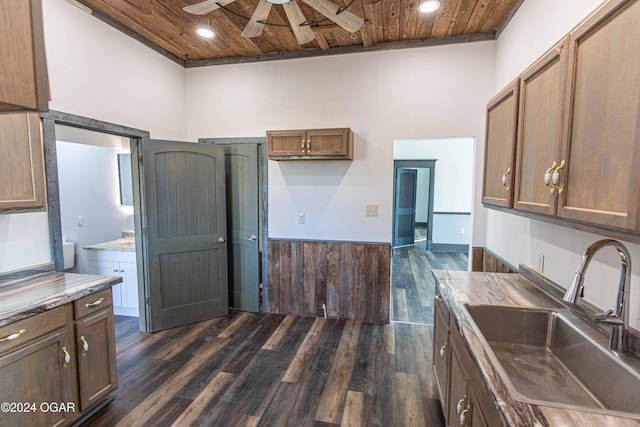 kitchen featuring ceiling fan, dark wood-type flooring, sink, wooden ceiling, and a high ceiling