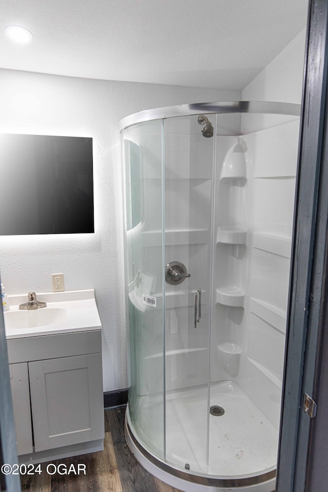 bathroom featuring hardwood / wood-style floors, vanity, and an enclosed shower