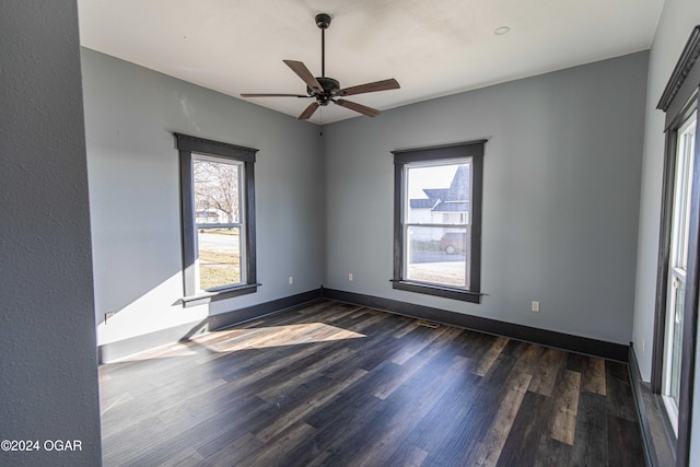 empty room featuring dark hardwood / wood-style flooring, plenty of natural light, and ceiling fan