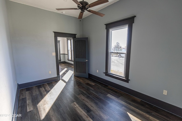 spare room featuring dark hardwood / wood-style flooring, ceiling fan, and a healthy amount of sunlight