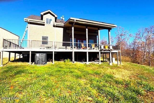 rear view of property featuring a wooden deck and a yard