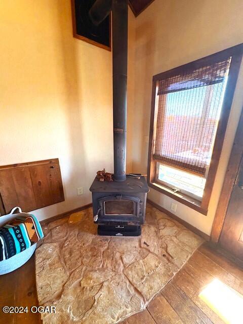 interior details featuring a wood stove and hardwood / wood-style flooring