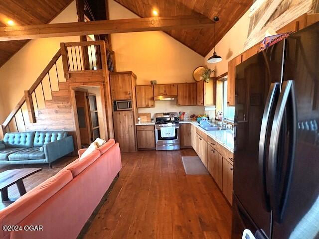 kitchen featuring beamed ceiling, dark hardwood / wood-style flooring, sink, and appliances with stainless steel finishes