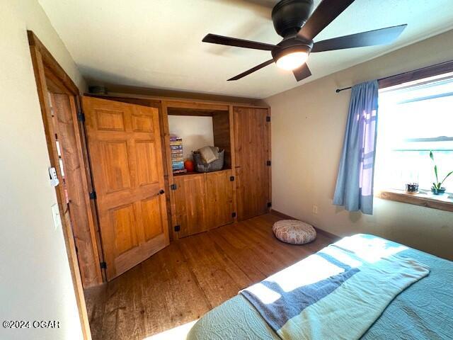 bedroom with ceiling fan and wood-type flooring