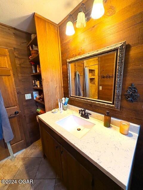 bathroom featuring tile patterned floors, vanity, and wooden walls