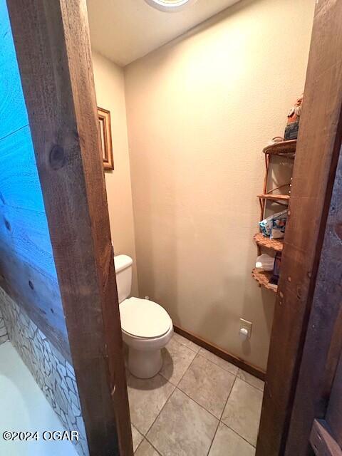 bathroom featuring toilet and tile patterned floors