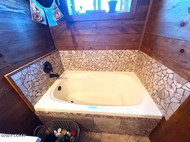 bathroom with a relaxing tiled tub