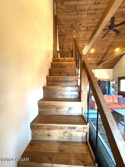 stairs with vaulted ceiling with beams, ceiling fan, and wood ceiling