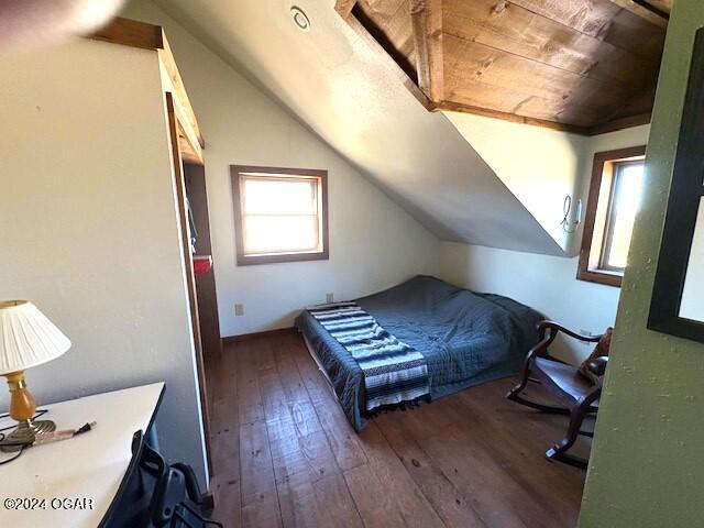 bedroom with dark hardwood / wood-style flooring, wooden ceiling, and vaulted ceiling