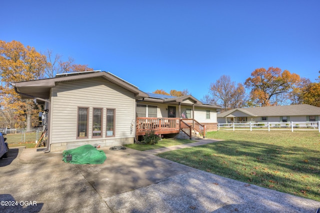 rear view of house featuring a yard and a deck