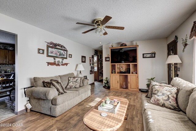 living room featuring a textured ceiling, hardwood / wood-style flooring, and ceiling fan