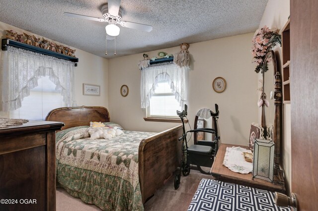 carpeted bedroom featuring ceiling fan and a textured ceiling