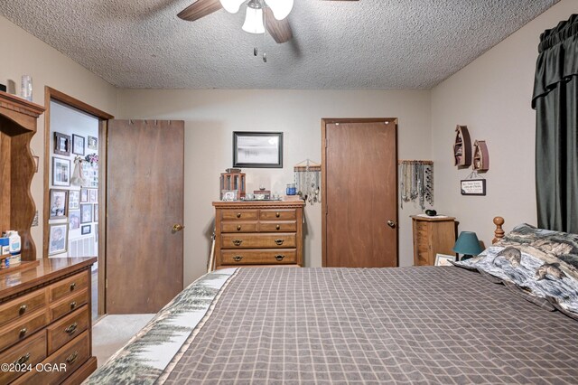 bedroom featuring light carpet, a textured ceiling, and ceiling fan