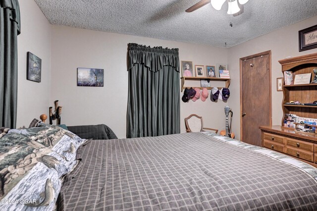 bedroom with ceiling fan and a textured ceiling