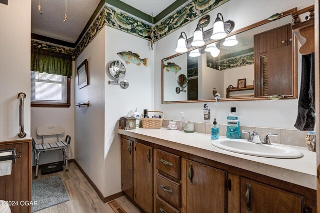 bathroom featuring vanity, hardwood / wood-style floors, and a textured ceiling