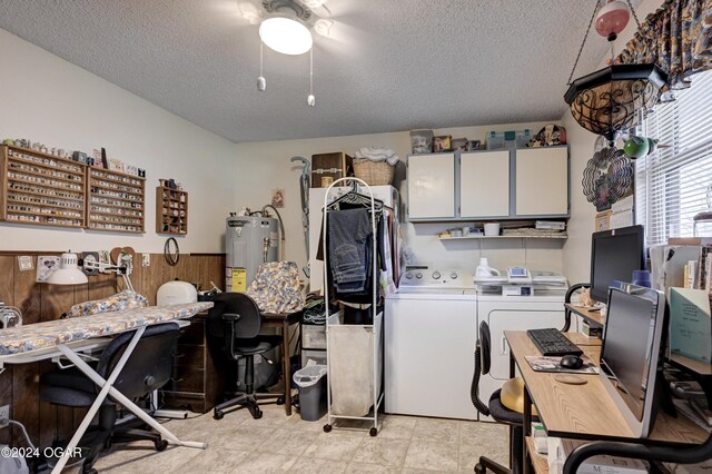 clothes washing area featuring washer and clothes dryer, cabinets, a textured ceiling, and water heater